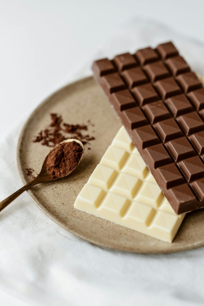 pexels-photo-4791265-4791265 A delicious assortment of milk and white chocolate bars with cocoa powder on a plate. Perfect for confectionery enthusiasts.